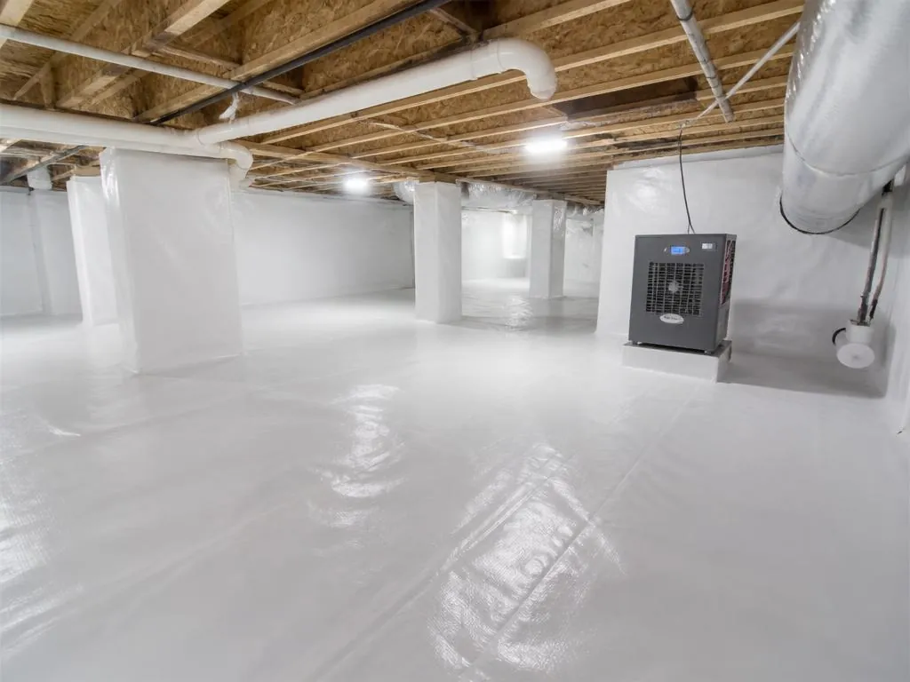 Bright, clean encapsulated crawl space with white vapor barrier and commercial dehumidifier